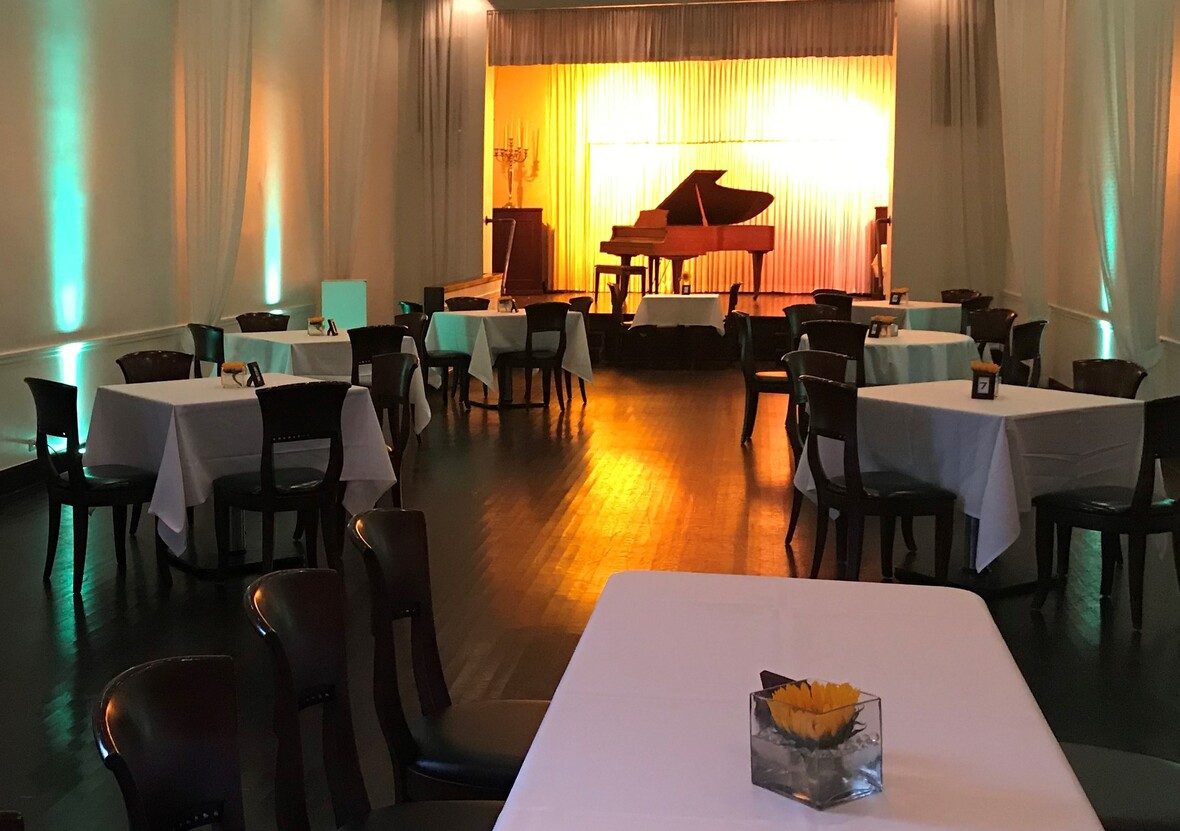 The grand piano stage glowing amber in the Old Eagle Room